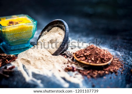 Close up of herbal face pack of tomato and turmeric with sandal wood,fuller's earth or mulatni mitti or mulpani mitti on wooden surface used to make your face glow in glass bowl with raw ingredients.