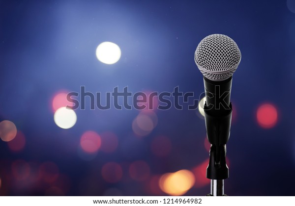 Close up of high fidelity microphone setting on stand\
with colorful light bokeh background in conference hall\
.\
Microphone on stage .