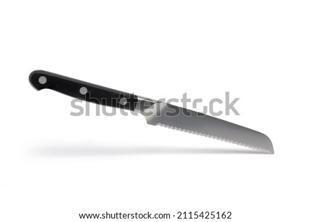 Close up of high quality small bread knife with black handle and serrated blade against white background