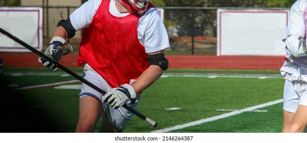 A Close Up Of A High School Boy Lacrosse Player Running With The Ball During A Scrimmage On The Attack.
