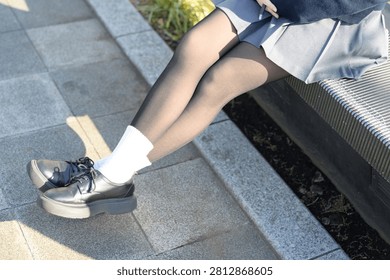 Close up of high school girl’s legs while sitting on bench