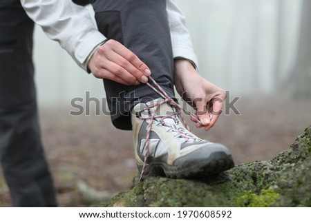 Close up of a hiker hands tying boot laces in the mountain