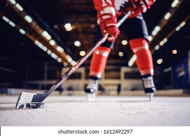 Close up of hockey player skating with stick and puck.