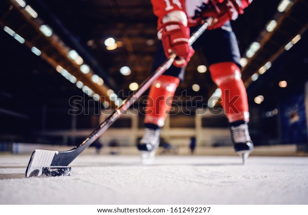 Close up\
of hockey player skating with stick and\
puck.