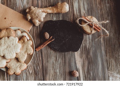 Close up of homemade ginger cookies, cinnamon, ginger on a wooden table. Copy space. Vintage toned image, flat lay