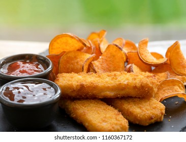 Close Up Homemade Organic Baked Fried Sweet Potatoes Chips And Fish Fingers Served Home Made Tomato Sauce And Barbecue Sauce On Black Slate Plate, Healthy Snack For Family Concept