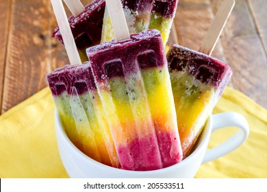 Close up of homemade pureed fresh fruit popsicles sitting in white cup - Powered by Shutterstock