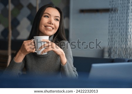 Close up horizontal shot of businesswoman sitting and enjoying coffee pause during work day with outside look at caf?. Break after working shift with hot beverage [[stock_photo]] © 