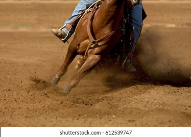A close up of a horse and rider with dirt flying.