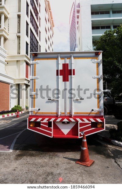 Close up hospital medical truck\
in the public street under COVID-19 situation in the new normal\
living life, as the building in and day light in the\
background