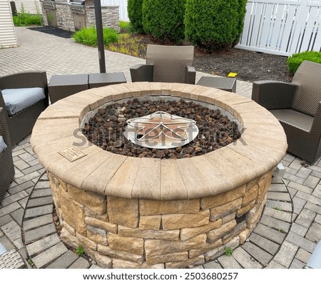 Close up a Hotel Fire Pit surrounded by chairs in a courtyard.