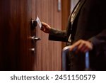 Close up of hotel guest entering a room with keycard.