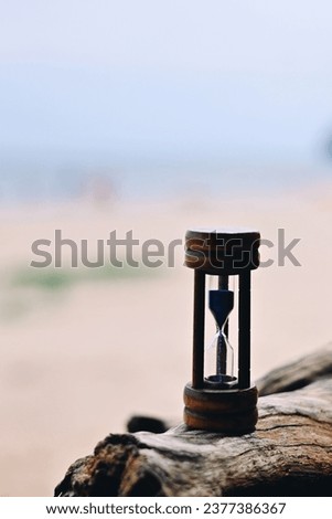 close up hourglass on old wooden log, nature copy space for text, saving and manage time to success business, relaxation and lifestyle concept