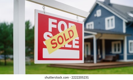 Close Up of a House Sold Sign on a Lawn in Front of a Big Modern House with Traditional Architecture. Housing Market Concept with Residential Property in the Countryside. - Powered by Shutterstock