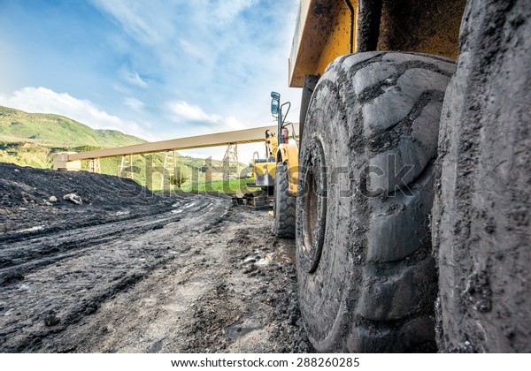 Close up of huge\
coal mining machines\'\
tires
