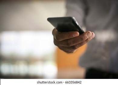 Close Up Of Human Hand. Business Man Holding And Typing On Smart Phone.