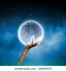 Close Up Of Human Hand Holding Blue Glowing Moon