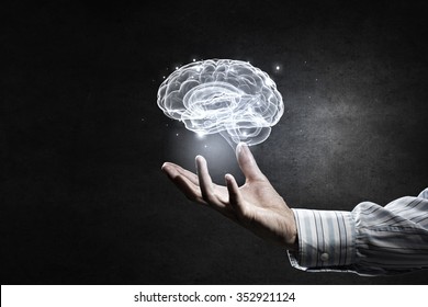Close up of human hand holding brain symbiol