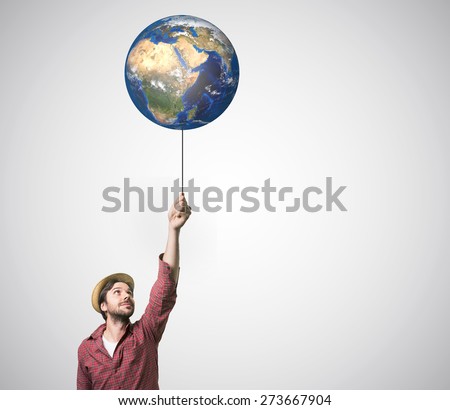 Close up of human hand holding Earth planet on rope.