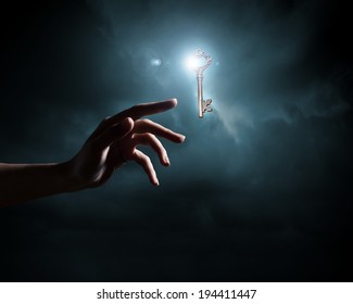 Close up of human hand holding key - Powered by Shutterstock