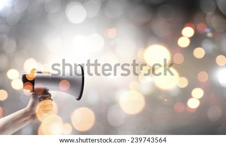 Close up of human hand holding megaphone