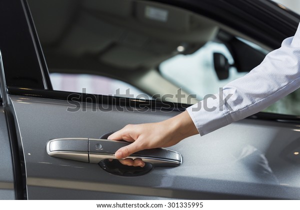 Close up of human\
hand opening door of car