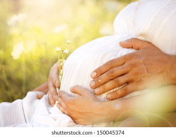 Close up of human hands holding pregnant belly