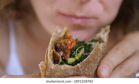 Close Up Of Hungry Female Mouth Taking A Bite Of A Wrap Sandwich And Chewing It With A Great Appetite 