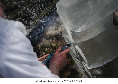Close up of an ice carver and ice sculptor working with a block of ice. - Shutterstock ID 2247377029