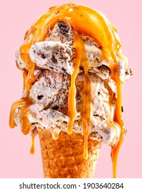 Close Up Of Ice Cream Cone With Cookies And Cream And Caramel Sauce Dripping 