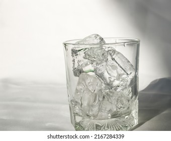 Close up of ice cubes in transparent glass on white background.
