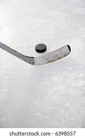 Close Up Of Ice Hockey Stick On Ice Rink In Position To Hit Hockey Puck.