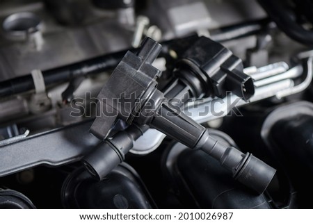 Close up ignition coil in the engine room, car maintenance concept. 