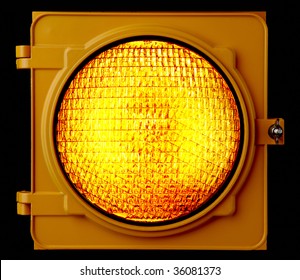 Close Up Of Illuminated Amber Traffic Light Lens