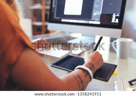 Close up of an illustrator using a digital writing pad to make a creative drawing. Artist making a creative design on a computer.