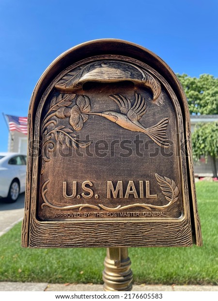 The close up image of an antique, copper finished
mailbox. It has the words 