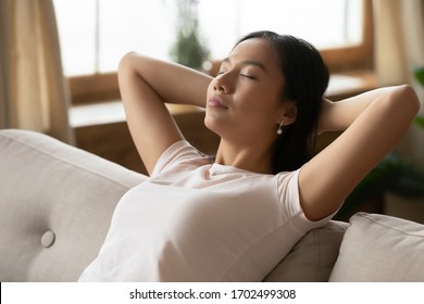 Close Up Image Asian Ethnicity Millennial Woman Resting Leaned On Couch In Living Room. Breath Fresh Air, Reduce Fatigue, Enjoy Weekend Free Time At Modern Home Alone, No Stress Inner Harmony Concept