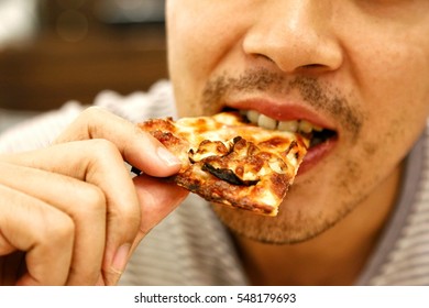 Close Up Image Of A Asian Man Eating Pizza