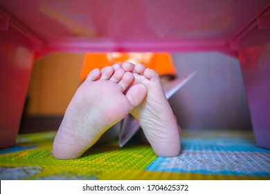 Close Up Image Of Baby Feet Under Japanese Table While Sitting On Soft Sheet