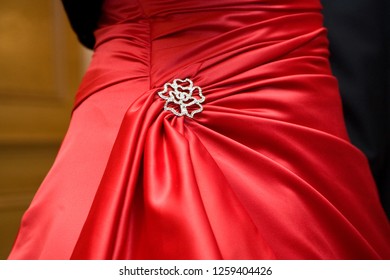 Close up image of the back of a red wedding dress and silver buckle