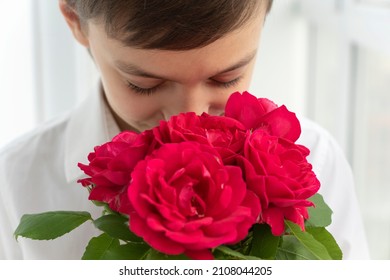 Close up image of boy in white shirt with bouquet of red roses, greetings concept, valentines day, mothers day, little gentleman