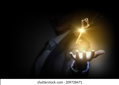 Close up image of business person holding shining key