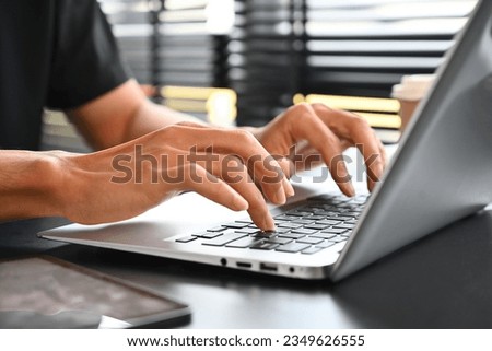 Close up image of businessman hand typing on laptop keyboard.