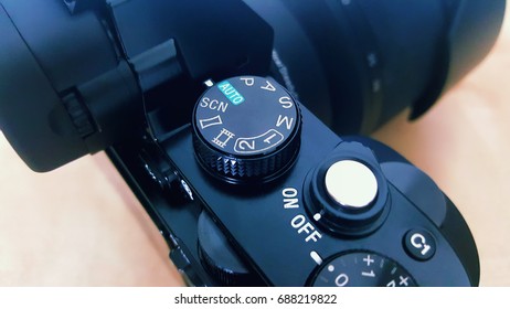 Close up image of camera buttons and dial. Auto mode. Wooden background. 
