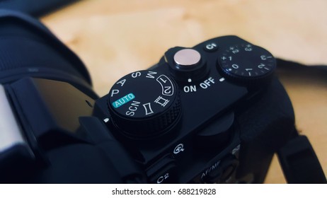 Close up image of camera buttons and dial. Auto mode. Wooden background. 