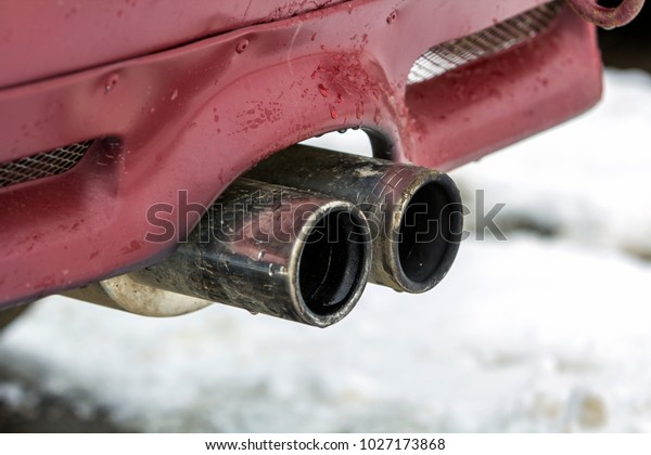 Close up image of a car dual exhaust pipe.\
Emission of poisonous carbon monoxide gas in atmosphere,\
environment pollution\
concept.