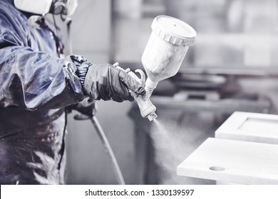 Close Up Image Of Carpenter Painting With A Paint Spray Gun