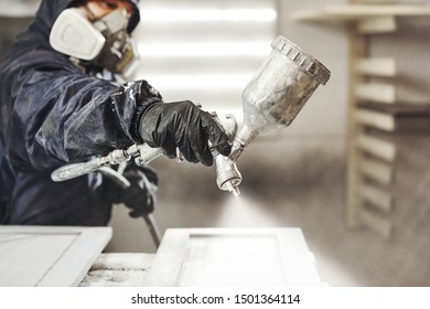 Close Up Image Of Carpenter Painting With A Paint Spray Gun