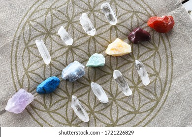 A close up image of chakra balancing crystals on a sacred geometry grid cloth. 