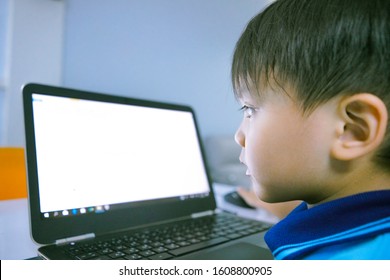Close up image of child face staring at computer screen, small kid looking at bright computer laptop screen at home